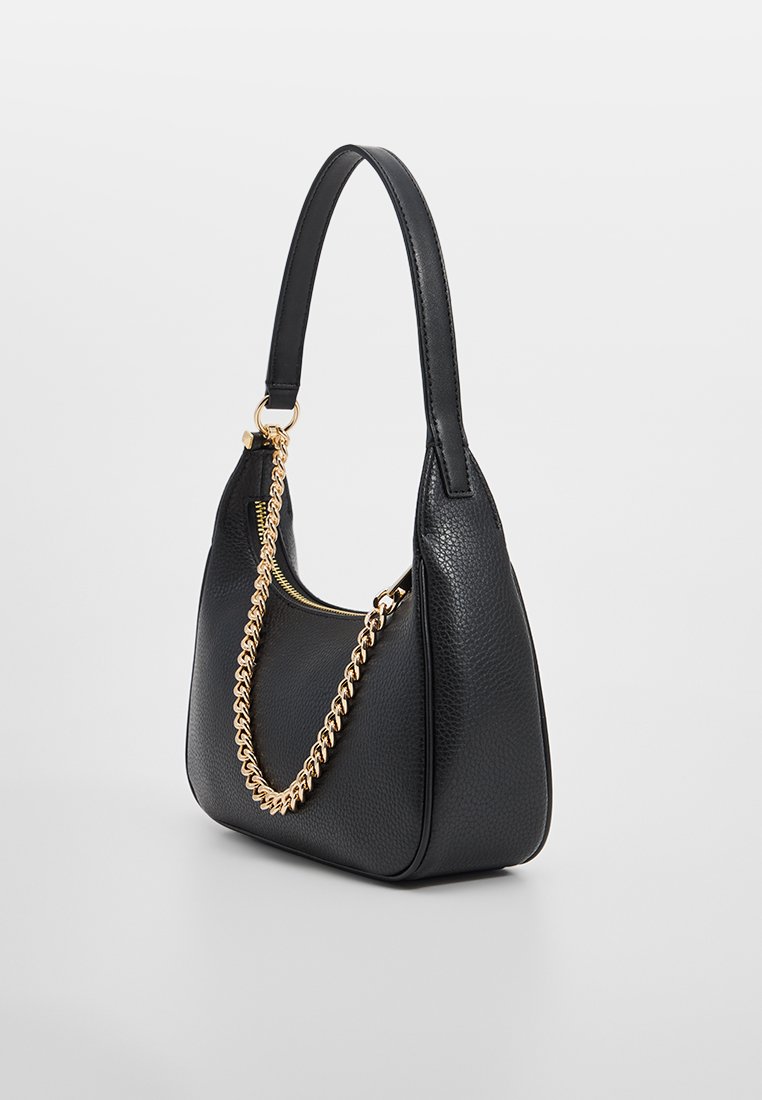 Schwarze strukturiert Lederhandtasche mit goldener Kettendetail und einem einzelnen Schulterriemen, schräger Blick auf einem schlichten weißen Hintergrund.