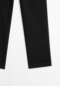 Czarne spodnie o gładkiej, matowej fakturze, z prostymi nogawkami i starannie wykończonymi brzegami, zaprojektowane dla uniwersalnego dopasowania.