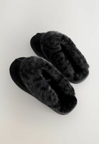 Pantofole nere con rivestimento in pelliccia morbida, tomaia in suede, design open-toe, suola piatta e una texture morbida per il massimo comfort.