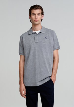 Graues Polohemd aus weichem Stoff, mit klassischem Kragen, kurzen Ärmeln und einem kleinen marineblauen Logo auf der Brust.