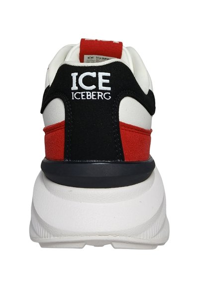 Baskets blanches avec des panneaux rouges et noirs, semelle blanche épaisse, et "ICE ICEBERG" brodé en blanc sur la languette au talon.