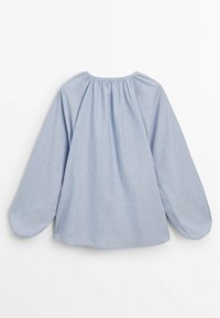 Chemise bleu clair à manches longues avec un col rond, un détail froncé au dos et un tissu fluide créant une apparence douce et texturée.