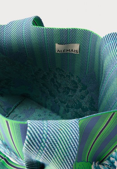 Ριγέ υφασμάτινη τσάντα με πράσινους, μπλε και μωβ τόνους, με ετικέτα στο εσωτερικό με το όνομα της μάρκας "ALÉMAIS."