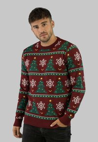 Knit sweater in maroon with green Christmas trees and white snowflakes. Features yellow stars and dotted borders. Ribbed cuffs and hem.