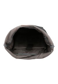 Sac à dos en tissu gris avec une fermeture enroulable et un intérieur imperméable. Présente un doublure douce avec un motif logo subtil et une sangle de maintien.