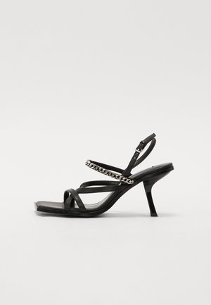 Čierne sandále na vysokom podpätku s viacerými vrstvami popruhov, reťazovým detailom na hornej časti a elegantným obdĺžnikovým dizajnom špičky.