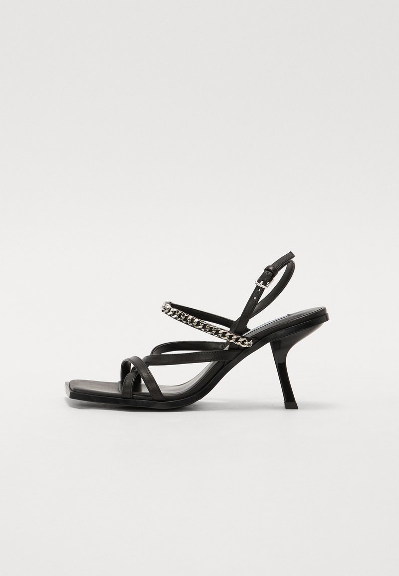 Μαύρες ψηλοτάκουνες σандάλες με πολλαπλές στρώσεις από λουριά, αλυσίδα σε όλη την πάνω πλευρά και κομψό σχέδιο τετράγωνης μύτης.