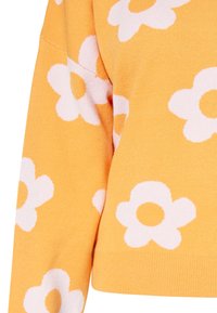 Maglione giallo realizzato in tessuto a maglia, caratterizzato da ampi motivi floreali bianchi con centri circolari. Design corto e orlo a coste.