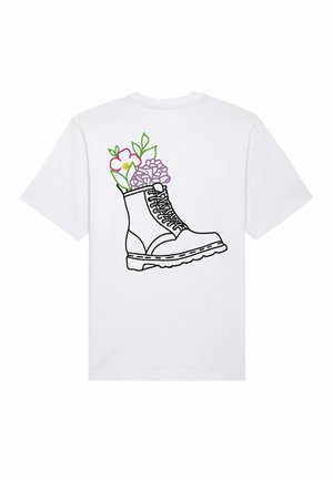 T-shirt blanc avec un contour noir d'une botte remplie de fleurs et de feuilles colorées, mettant en avant des détails verts, roses et violets.