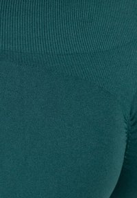 Leggings a vita alta in verde petrolio, con una trama a coste e un design senza cuciture per comfort e flessibilità.