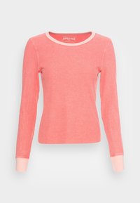 Långärmad ribbad t-shirt i korall med rundad halsringning och ljusrosa kant på ärmar och krage. Mjuk textur med en figurnära design.