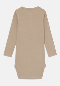 Långärmad bodysuit i ljusbeige ribbad tyg. Har en rundad halsringning och tryckknappar i botten för enkel påklädning.