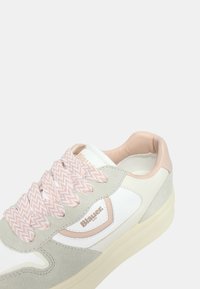 Sneaker bianca con accentuazioni rosa e lacci a zigzag. Presenta una tomaia in suede e pelle, punta arrotondata e un colletto morbido imbottito. Marchio Blauer.