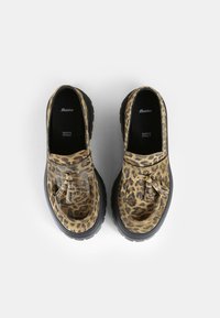 Scarpe con stampa leopardata realizzate in materiale testurizzato, con taglio basso e dettaglio decorativo a nappina, dotate di una spessa suola in gomma nera.