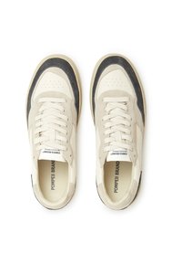 Beige i sivi sportski tenisice s teksturiranim gornjim dijelom, vezicama i zaobljenim vrhom. Sadrži brendiranje unutar i duž strana.