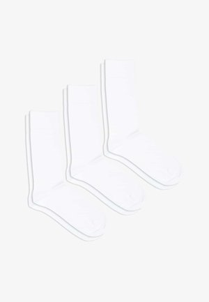 Three pairs of white cotton socks with a ribbed design at the cuff, featuring a reinforced toe and subtle branding on the side.