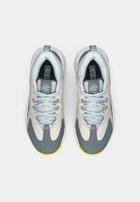 Hellgraue Sportschuhe mit dunkelgrauen Akzenten, Mesh-Details, flachen Schnürsenkeln und gelber Sohle. Ausgestattet mit einem gepolsterten Kragen und einer markenprägten Innensohle.