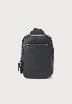 Sac bandoulière en cuir noir avec surface texturée, fermeture éclair argentée et logo subtil à l'avant. Design rectangulaire compact avec sangle ajustable.