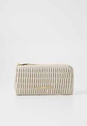 Beige teksturert lommebok med en samlet design og gullfargede detaljer, med glidelås og glatt lærfinish.