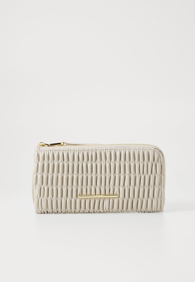Beige teksturert lommebok med en samlet design og gullfargede detaljer, med glidelås og glatt lærfinish.
