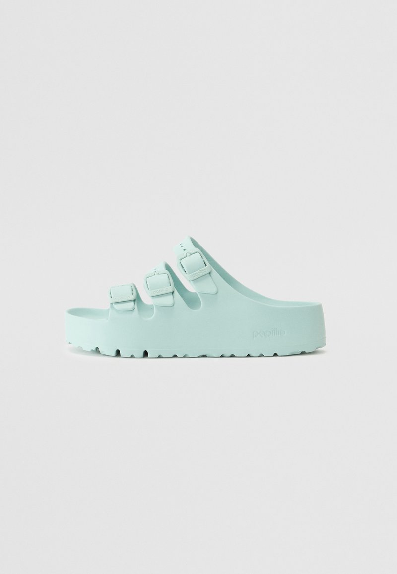 Sandali blu chiaro slip-on con tre cinturini regolabili, realizzati in materiale simile alla gomma, con suole testurizzate e logo del marchio sul lato.