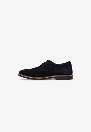 Zwarte suède veterschoenen voor heren met bruine rand op de zool, lage hak en blauwe stiksel details bij de hiel.