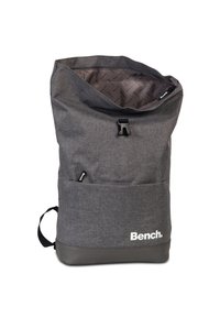 Sac à dos en tissu gris avec une ouverture supérieure, des bretelles ajustables et une base en caoutchouc. Présente un logo imprimé en blanc sur le devant.