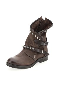 Brown leather ankle boot with studded black bead trim, silver studs, two leather straps with metal buckles, and low black heel.