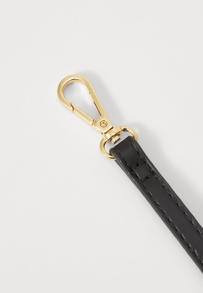 Sangle en cuir noir avec un clip en métal doré. Présente une texture lisse et des détails de couture le long des bords. Le clip dispose d'un mécanisme de fermeture sécurisé.