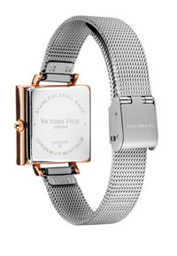 Montre avec un bracelet en maille en acier inoxydable argenté et un boîtier carré rehaussé d'or, dotée d'un fond réfléchissant et de gravures détaillées.