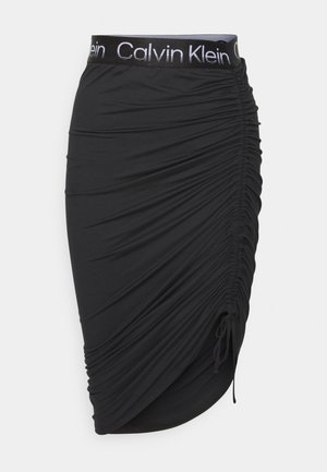 Jupe crayon noire froncée avec cordon réglable sur le côté et ceinture élastique de marque Calvin Klein.