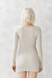 Abito a maniche lunghe in maglia beige con una texture a coste aderente, caratterizzato da un colletto rotondo e un orlo che termina a metà coscia.