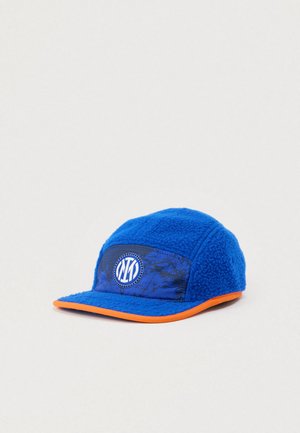 Casquette en polaire bleue avec une couronne texturée, un bord orange et un patch logo circulaire avec des initiales sur le panneau avant.