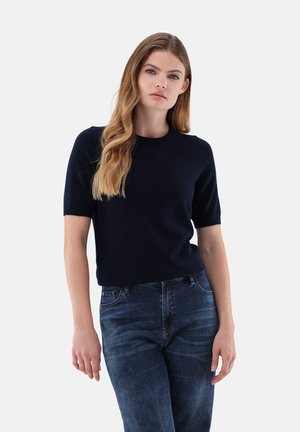 Marineblaues Kurzarmstrickoberteil mit Rundhalsausschnitt, aus weichem Material gefertigt. Kombiniert mit blauen Jeans im klassischen Schnitt.