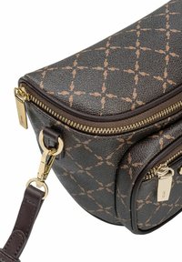 Zbliżenie na ciemnobrązową torebkę na ramię o teksturowanej powierzchni, z beżowym wzorem w diamenty, złotymi uchwytami zamka błyskawicznego oraz odpinanym zapięciem ze skórzanego paska.