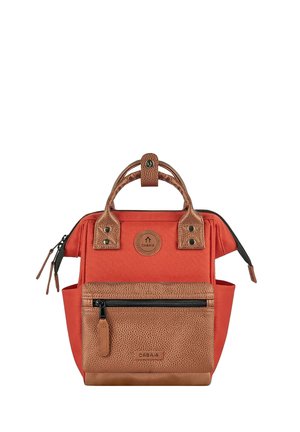 Kleiner roter und brauner Rucksack mit zwei Griffen, Reißverschlusstasche vorne, Seitentaschen und Cabaia-Logopatches auf der Vorderseite und am Griffverschluss oben.