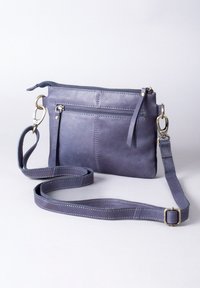 Purple leather crossbody bag with a zip closure, adjustable strap, front pocket, and contrasting stitching detail. Smooth texture.