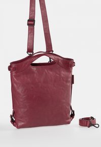 Leren tote bag in donkerrood met een gladde textuur. Beschikt over een bovenhandvat en een verstelbare schouderriem. Minimalistisch ontwerp, geen zichtbare hardware.