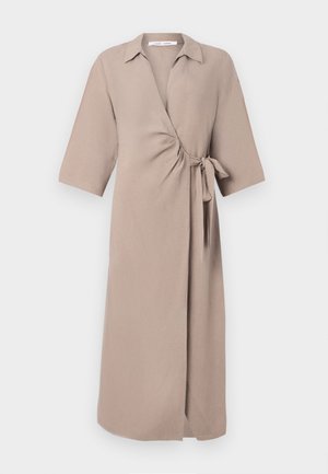 Beige wrap dress in lightweight fabric, featuring a V-neck, short sleeves, and a tied accent at the waist. Mid-length design.