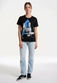 Black T-shirt featuring a graphic of a character with hand raised, blue background, and text "Live Long and Prosper." Casual fit, cotton material.