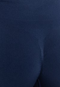 Mörkblå leggings gjorda av stretchigt material med en slät yta. Hög midja och åtsittande design, inga synliga mönster eller detaljer.