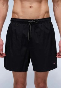 Juodos maudymosi šortai, pagaminti iš lengvos medžiagos. Yra elastinga juosmens juosta su raišteliu, šoniniais kišenėmis ir mažo logotipo detale.