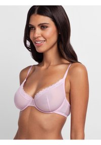 Light pink bra with lace trim, underwire support, and adjustable straps. It features a silky texture and a sheer back design.