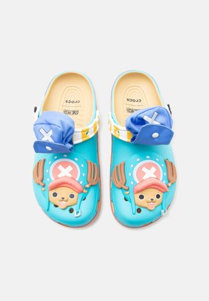 Blå slip-on sko med tegneserie elg-ansikter på tærne og festede blå stoffklaffer med hvite kryss.