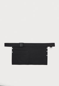 Svart stoffverkstedforføyse med bred belte, med trykknapper på den ene siden og en metallring for feste på den motsatte siden.