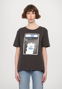 Donkergrijs katoenen T-shirt met een grafische print van een gezicht met krullend zwart haar en blauwe accenten. Korte mouwen, ronde halslijn, comfortabele pasvorm.