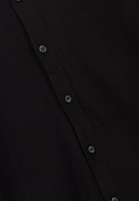 Svart knapp-up skjorta i mjukt tyg, med en vertikal rad av svarta knappar och en slät yta. Inga mönster eller detaljer närvarande.