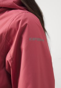 Pink waterproof jacket featuring a soft texture, flexible fit, and the "ICEPEAK" logo in gray on the left shoulder.
