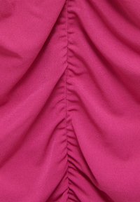 Fuchsiová látka s nařasenou texturou podél středové části. Materiál vypadá hladce s mírným leskem, což zdůrazňuje jemné, splývavé záhyby.