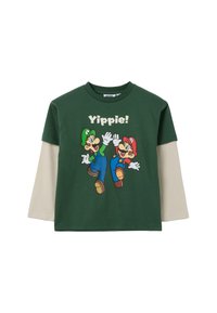 Groene longsleeve t-shirt met een afbeelding van twee geanimeerde figuren en de tekst "Yippie!", aangevuld met beige mouwen.